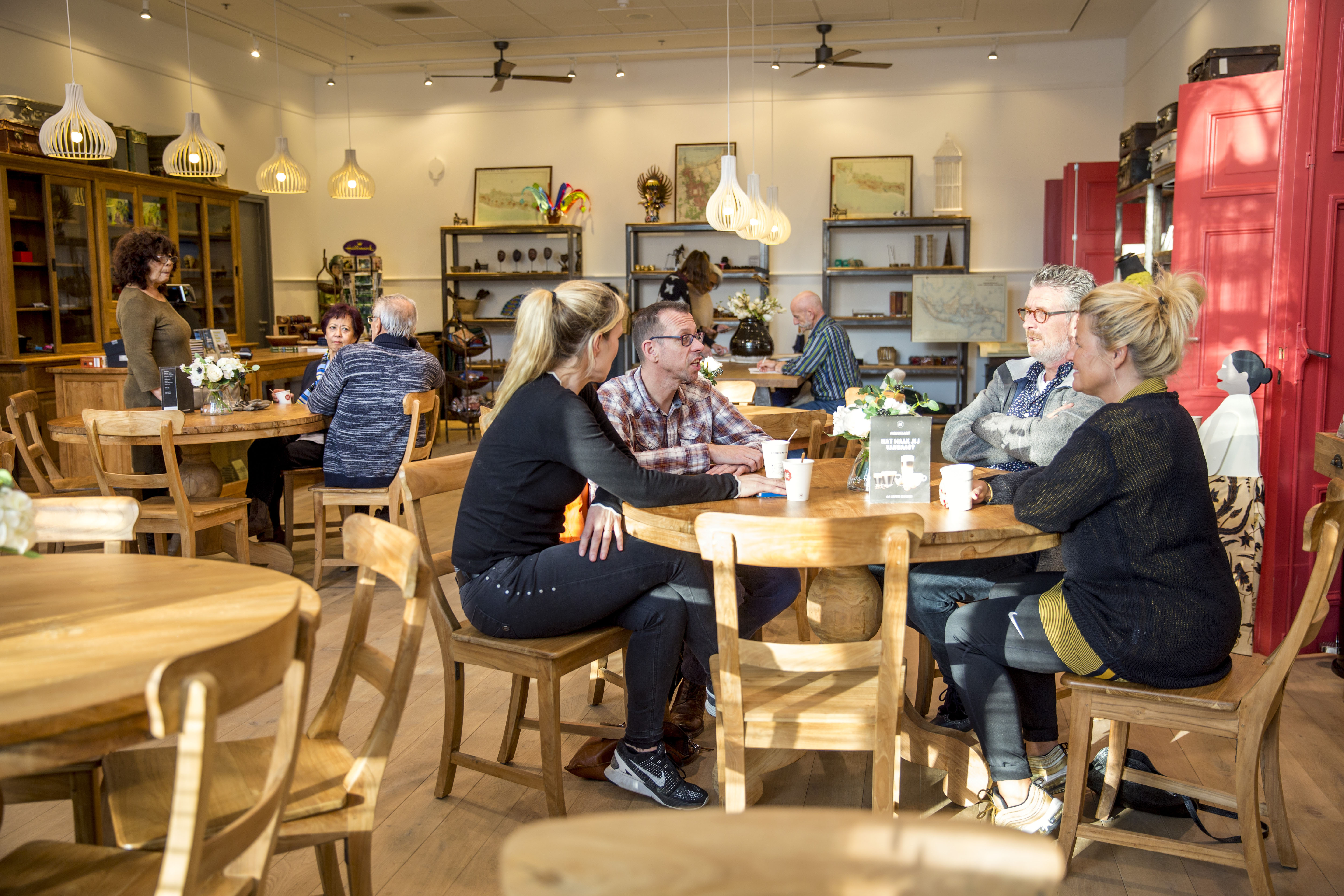 Bezoekers drinken koffie in café Batavia